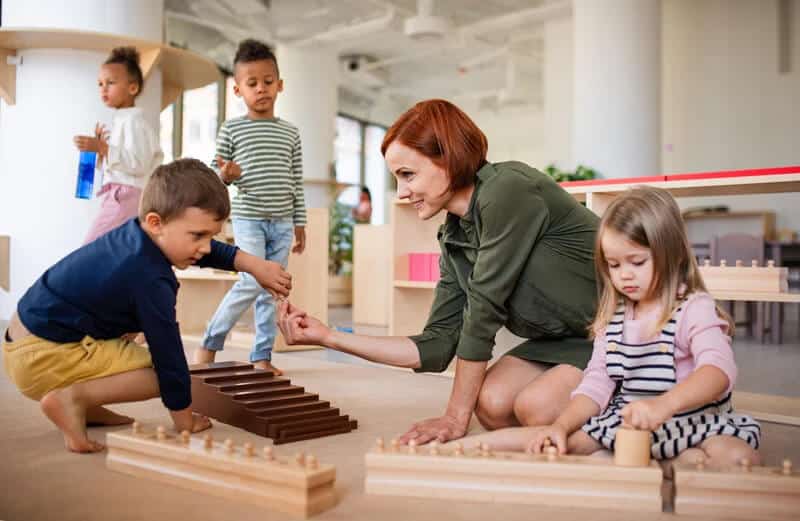 Montessori Apprentice Academy classroom setting with children and teacher engaged in Montessori activity